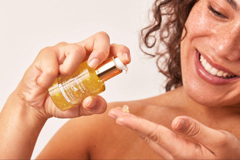 A woman dispenses Lemon & Beaker’s Vitamin C Serum unto her fingertips.